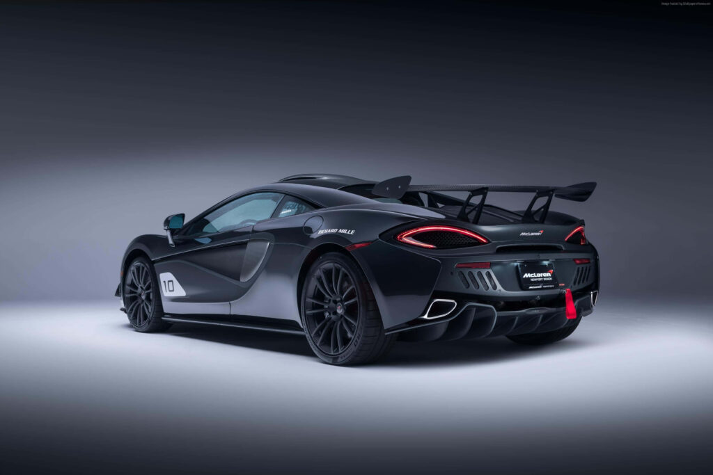 Rear view of McLaren GT1 with aerodynamic design and black finish on studio wallpaper background