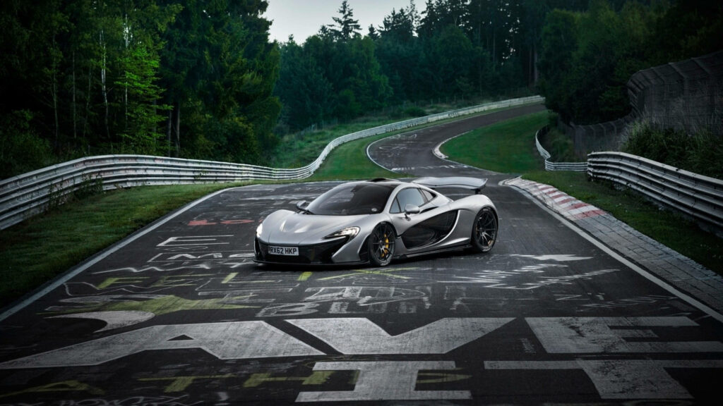 McLaren P1 racing car on graffiti racetrack surrounded by green trees sporty wallpaper background
