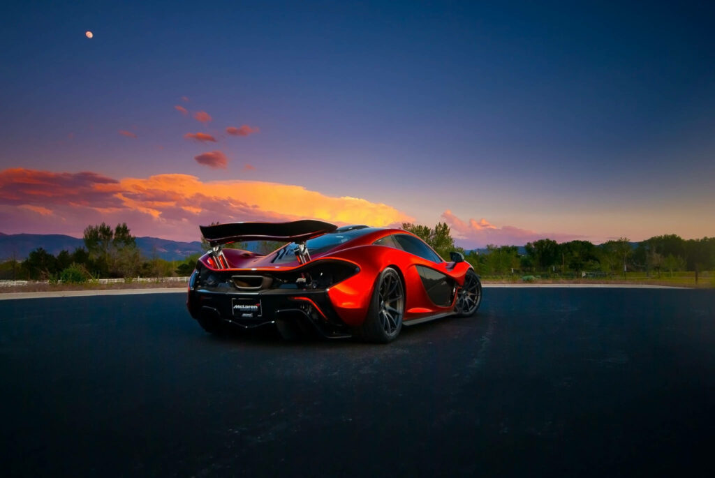 Rear view of McLaren P1 sports car on open road at sunset showcasing sleek design wallpaper