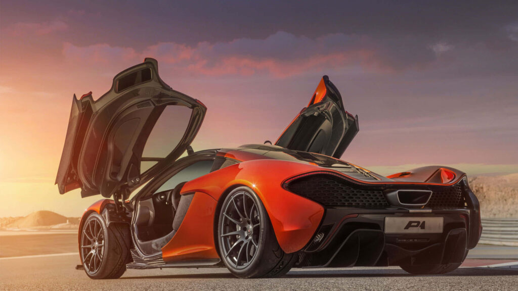 McLaren P1 with doors open at sunset on racetrack high performance supercar wallpaper background