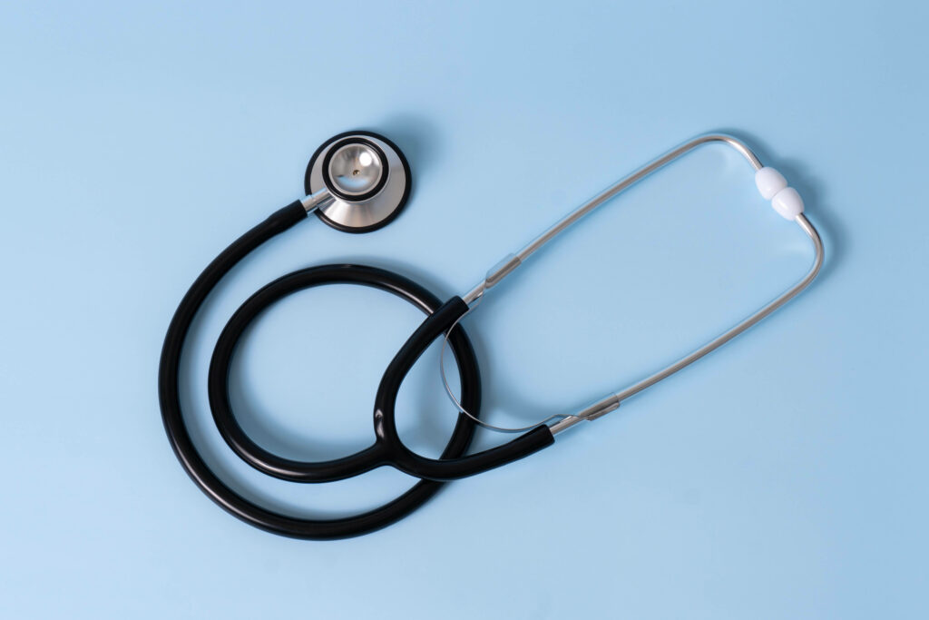 Medical Essential on Calm Blue Background: A Vibrant Stethoscope on a Pristine Surface Wallpaper
