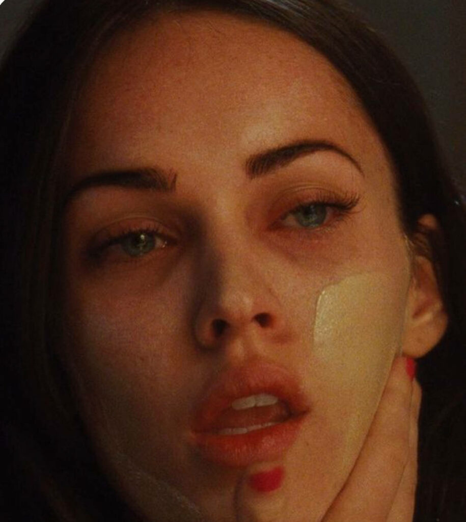 Close-up grunge wallpaper of Megan Fox in Jennifer's Body with intense expression and beauty