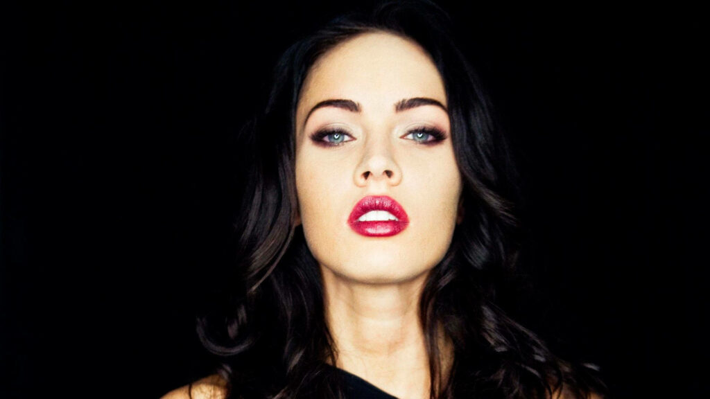 Megan Fox seductive pose with red lips confident expression dark background wallpaper image