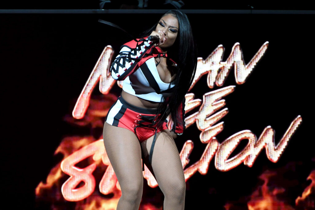 Megan Thee Stallion's Energetic Stage Performance: Bold Red & Black Wallpaper
