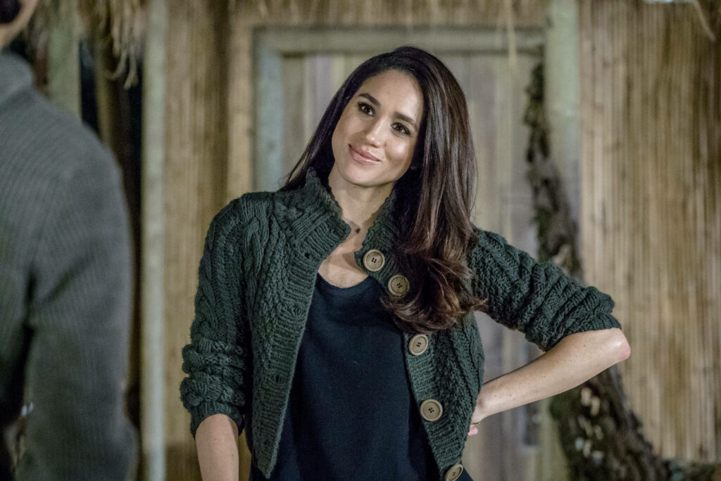 Meghan Markle in dark textured sweater smiling warmly in rustic cozy Dater's Handbook scene Wallpaper