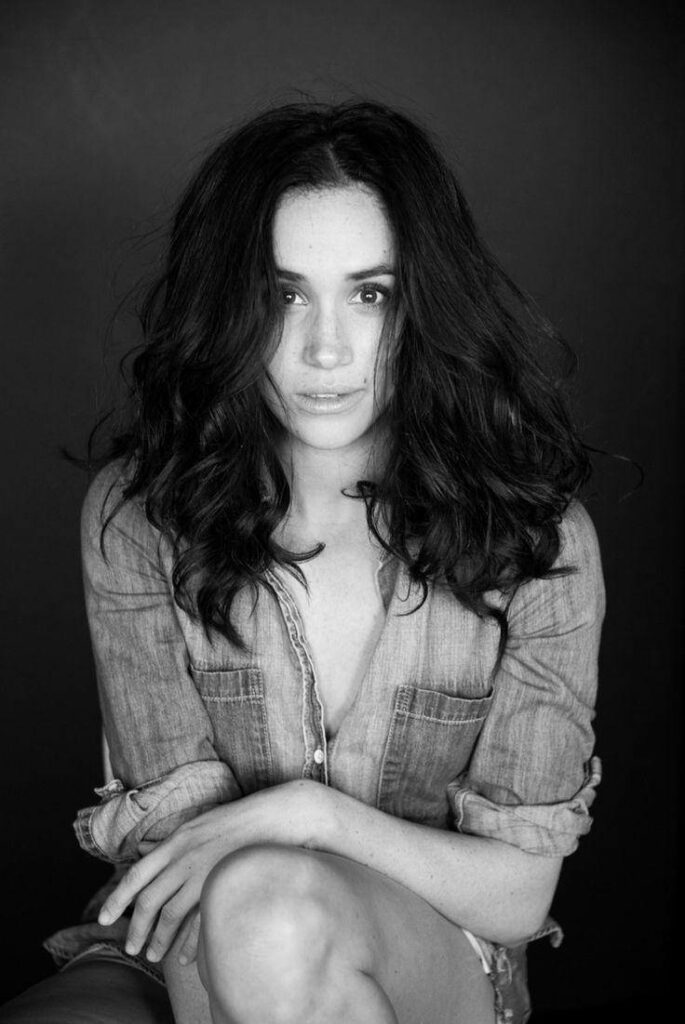 Monochrome portrait of Meghan Markle showcasing natural beauty and confident relaxed pose background Wallpaper
