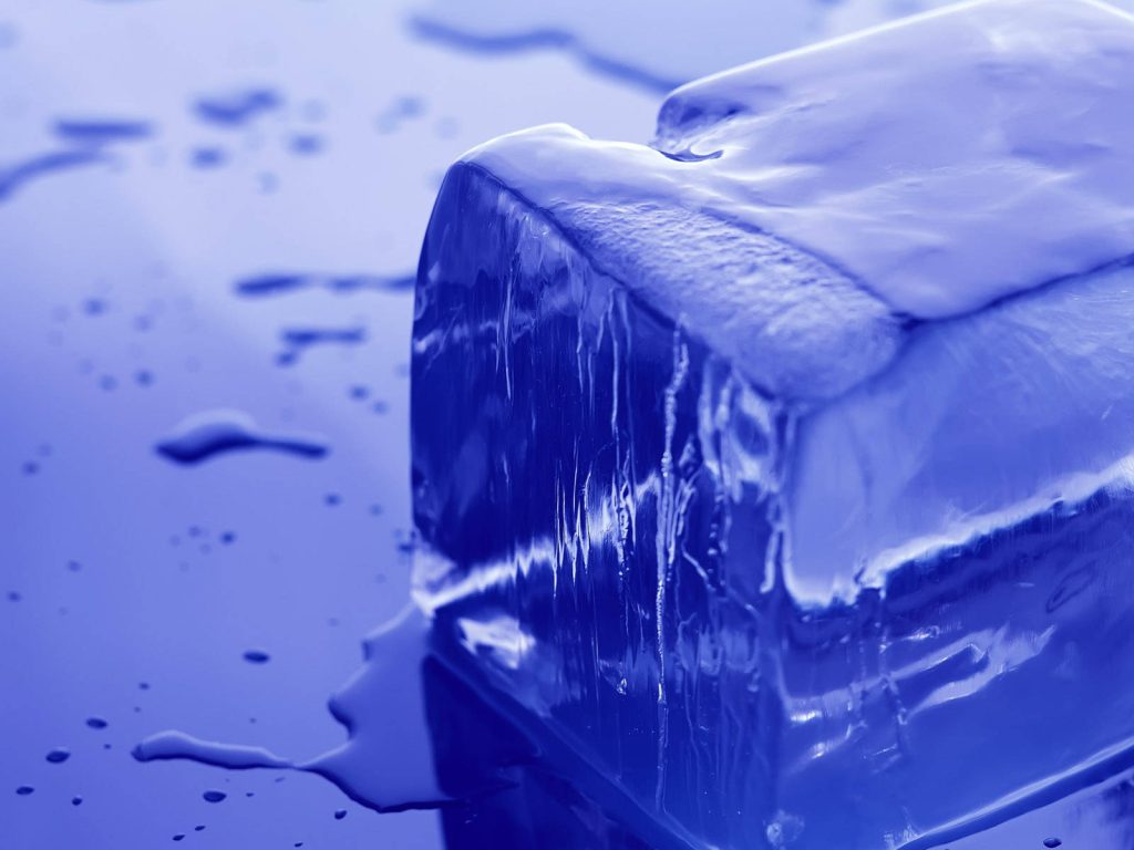 Macro close-up of melting ice cube on reflective blue surface with vibrant cool tones wallpaper