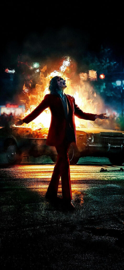 The Jovial Joker: Joaquin Phoenix in a Fiery Background - An Explosive Iphone 11 Wallpaper