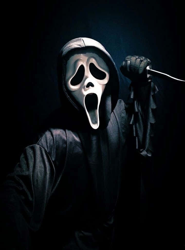 Sinister Shadows: Eerie Scream Ghostface Wallpaper Showcasing the Iconic Slasher, Ghostface, Brandishing a Knife against a Mysterious Black Background