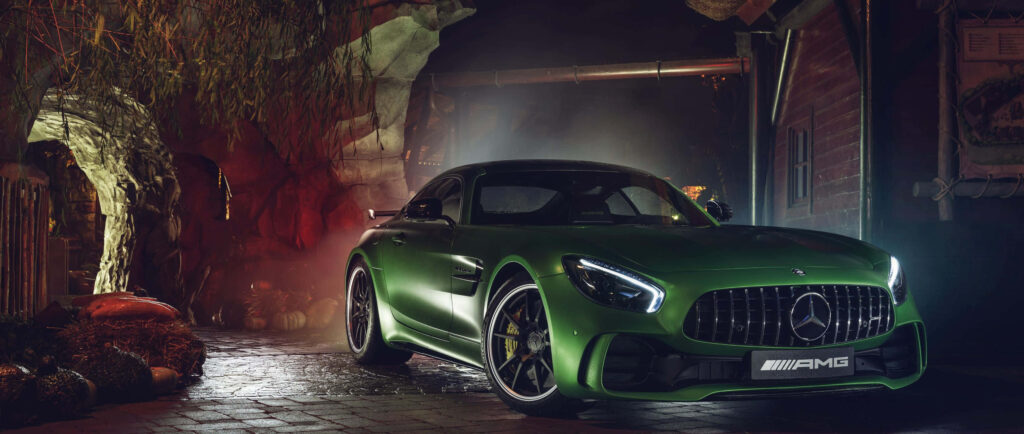 Dark green Mercedes AMG showcased in dim light highlighting bold curves and aggressive design Wallpaper