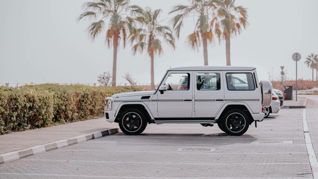 Mercedes AMG G Class parked on sunny palm tree road luxury travel adventure wallpaper background