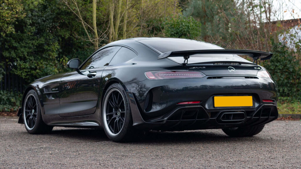 Mercedes AMG GT-R black sleek sports car with rear spoiler parked on quiet road dynamic design Wallpaper