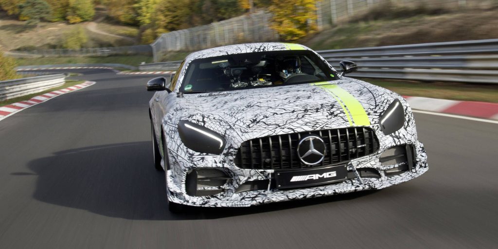 Mercedes AMG GT R prototype cornering on racetrack with black white camo and yellow stripe wallpaper