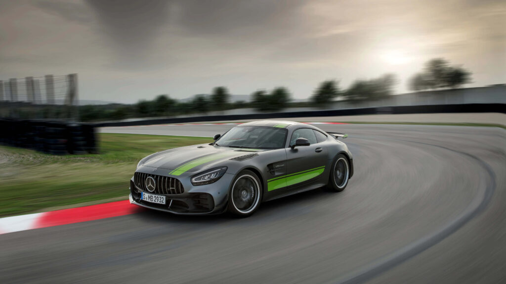 Mercedes AMG GT R speeding on racetrack with vivid green accents dynamic design wallpaper