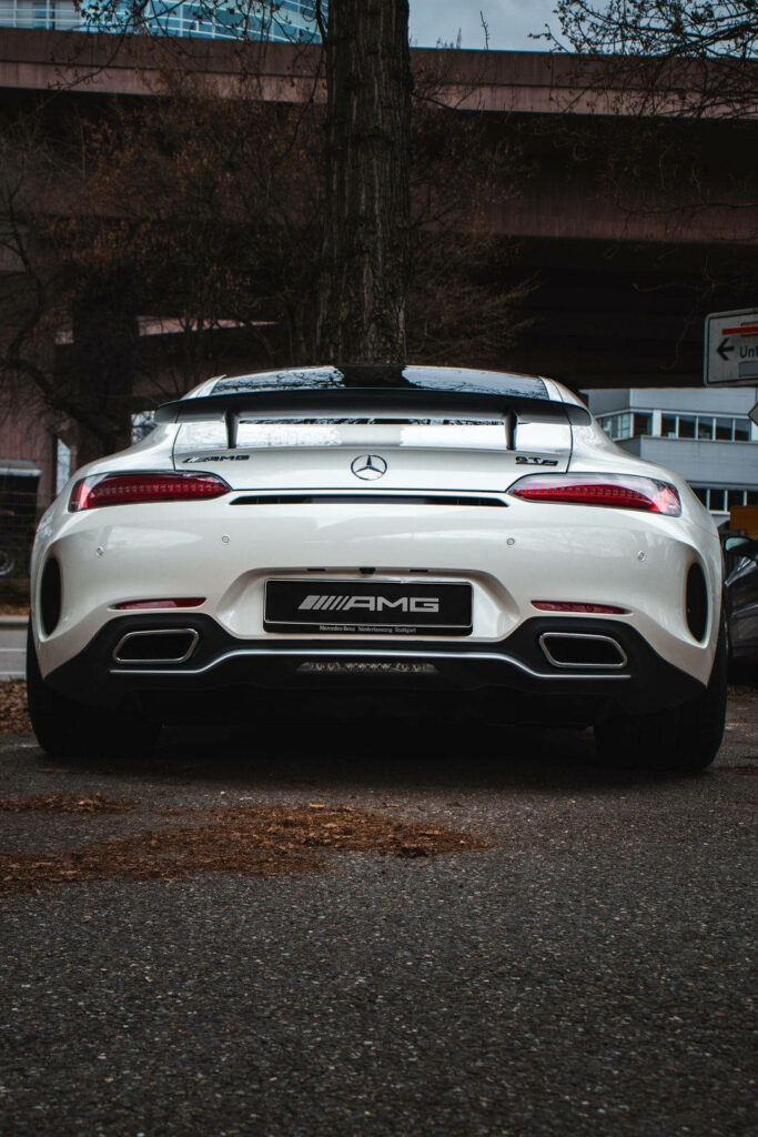Rear view of white Mercedes AMG GT R with bold branding dual exhausts outdoor wallpaper background
