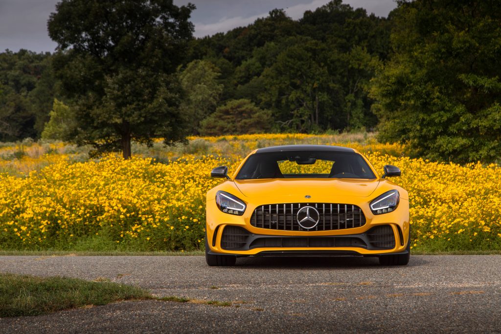 Mercedes AMG GT R solar yellow sports car in wildflower field with Panamericana grille view Wallpaper
