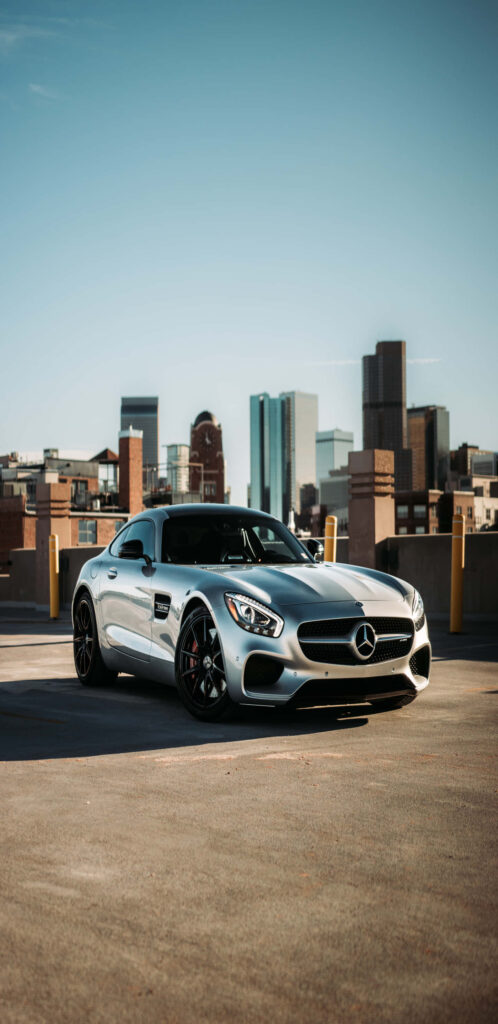 Mercedes-Benz AMG GT-R parked on rooftop with modern city skyline highlighting sleek design Wallpaper