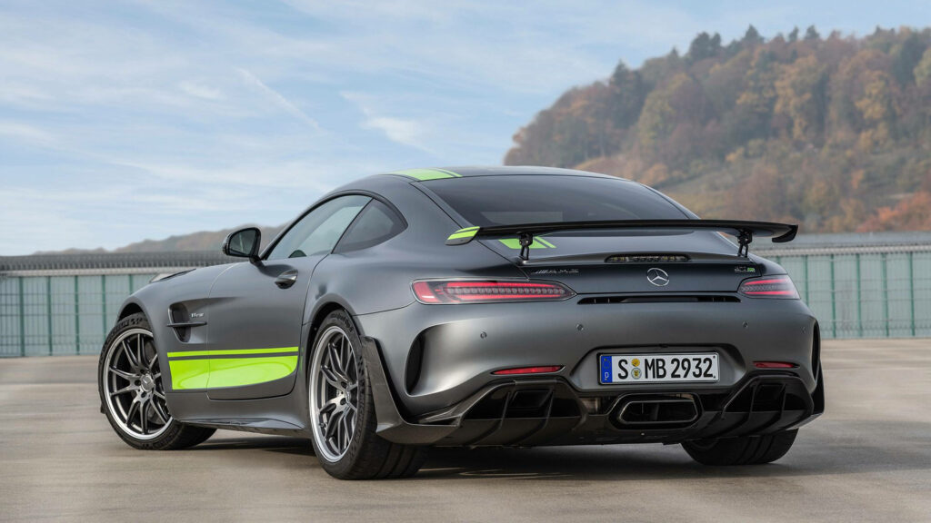 Mercedes AMG with bold rear spoiler and green accents parked outdoors high-resolution wallpaper