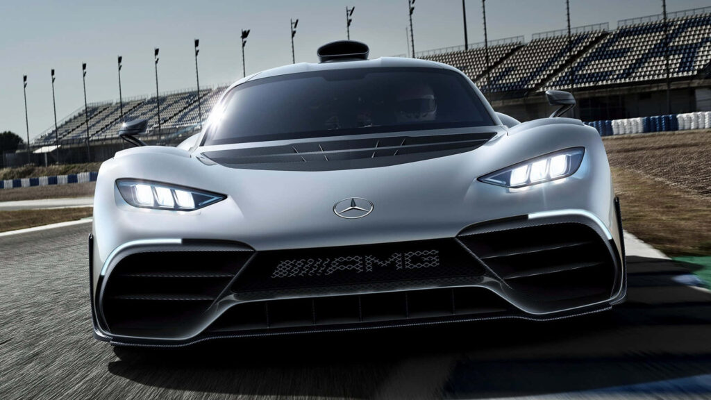 Mercedes AMG on racetrack with bold white headlights aggressive grille empty grandstand background Wallpaper