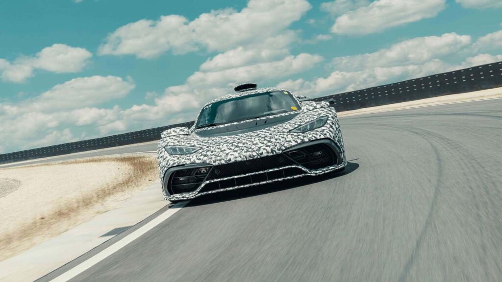 Mercedes AMG speeding on racetrack under blue sky with clouds showcasing sporty design wallpaper