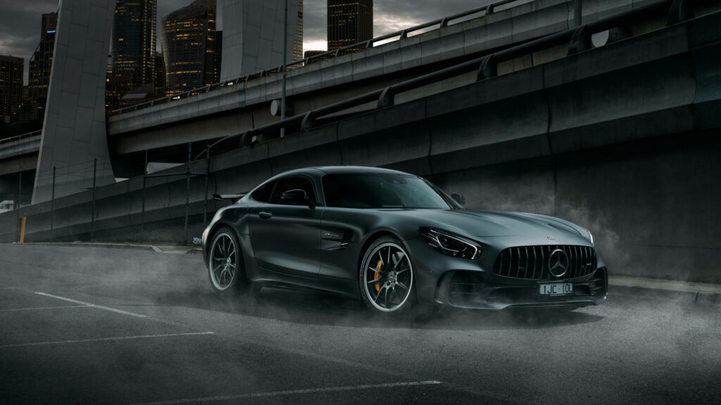 Mercedes AMG car parked by urban ramp with city buildings and dramatic shadows in 4K detail Wallpaper