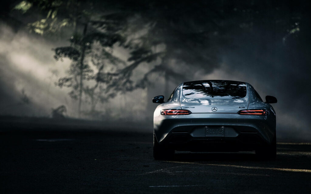Mercedes AMG parked in shadows with dramatic lighting highlighting sleek contours misty forest background Wallpaper