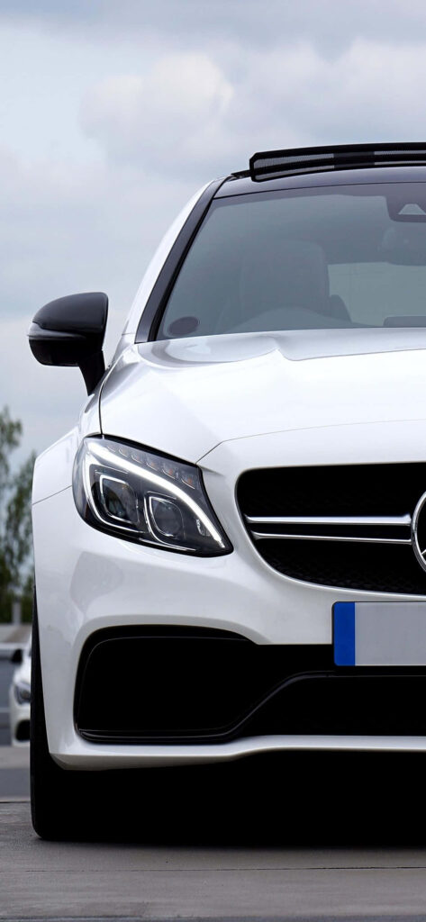 Close-up of white Mercedes-Benz C-Class front with sleek design and modern headlights outdoors Wallpaper