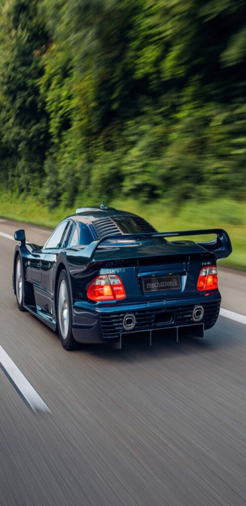 Mercedes-Benz CLK AMG GT-R racing on highway with aerodynamic design and bold rear wing greenery Wallpaper