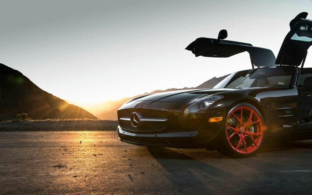 Sleek Mercedes-Benz SLS with Gullwing Doors Against Sunset Mountains Wallpaper