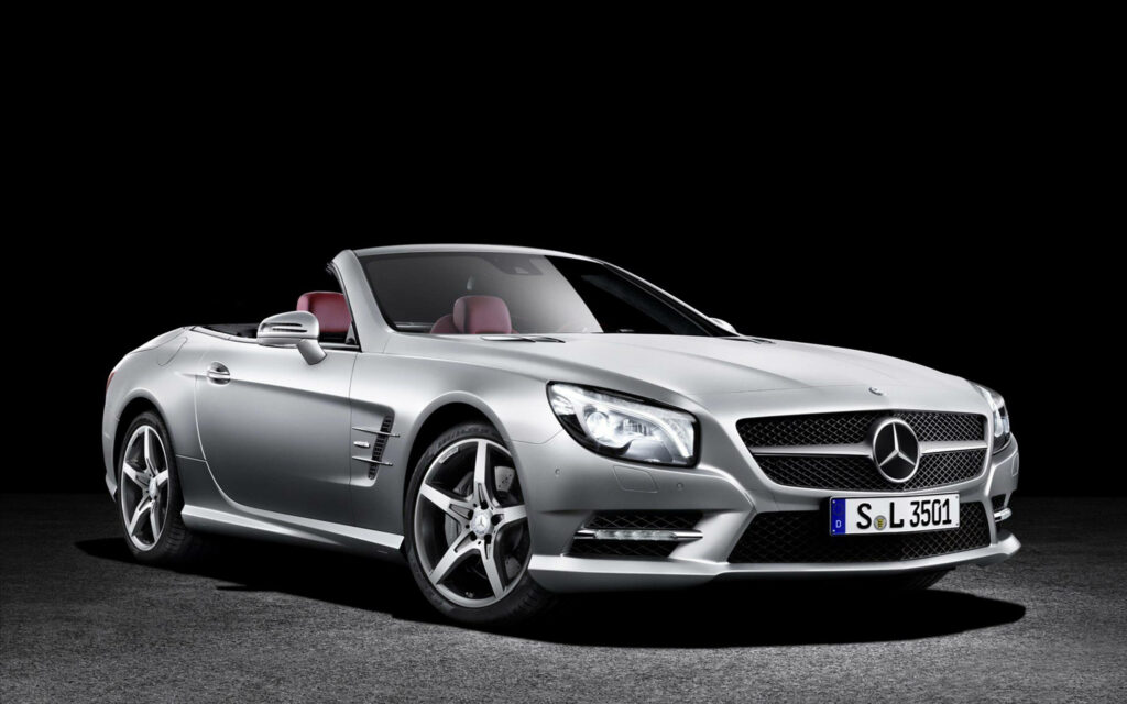 Silver Mercedes-Benz convertible with luxurious red leather interior on dark wallpaper background