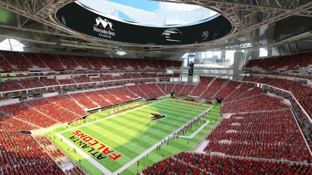 Mercedes-Benz Stadium interior with Atlanta Falcons logo and vibrant fans on game day wallpaper