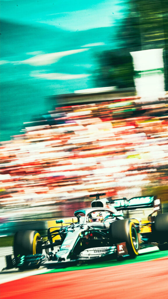 Mercedes F1 car speeding past vibrant blurred crowd dynamic racing iPhone wallpaper background