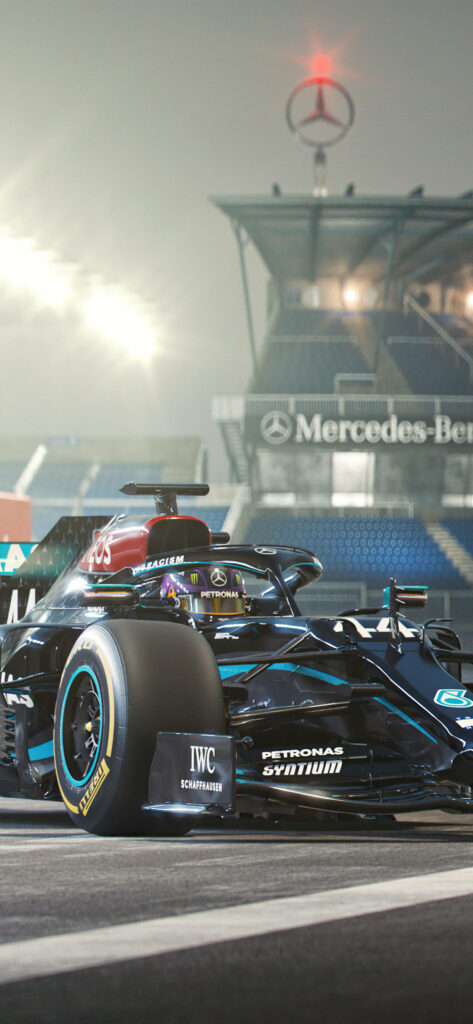 Mercedes Formula 1 car sideways on racetrack with Mercedes-Benz grandstand and emblem backdrop Wallpaper