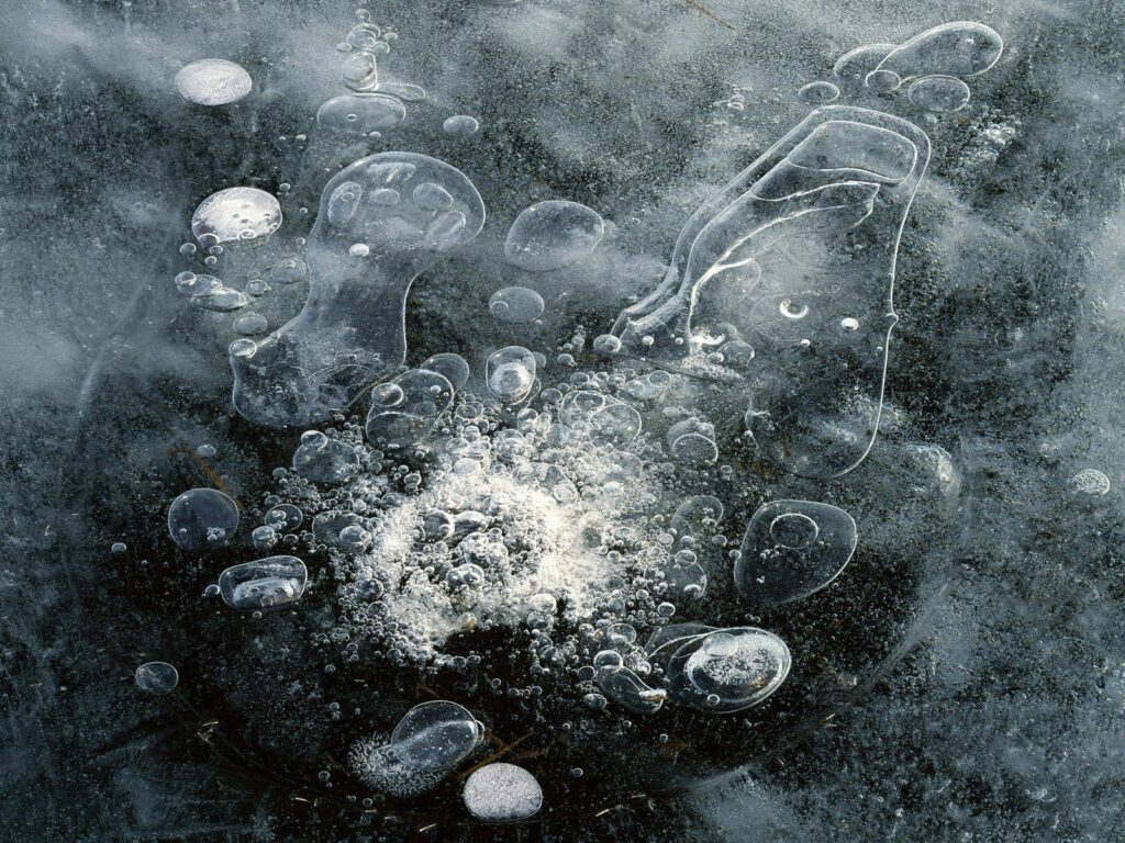 Abstract winter wallpaper with blue white bubbles trapped under clear ice pattern background