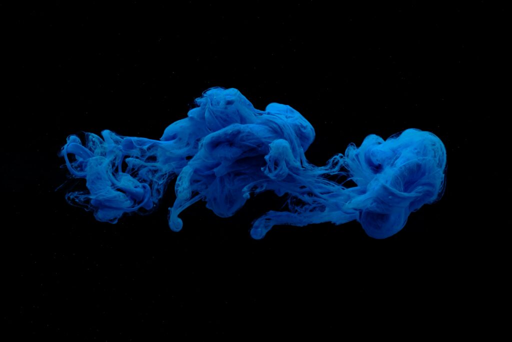 Mesmerizing Blue Ink Swirls on Black Background - Stunning Wallpaper