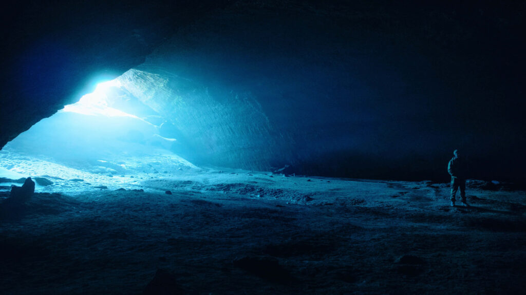 Mesmerizing Cave Wallpaper: Soft Blue Light & Silhouette Adventure
