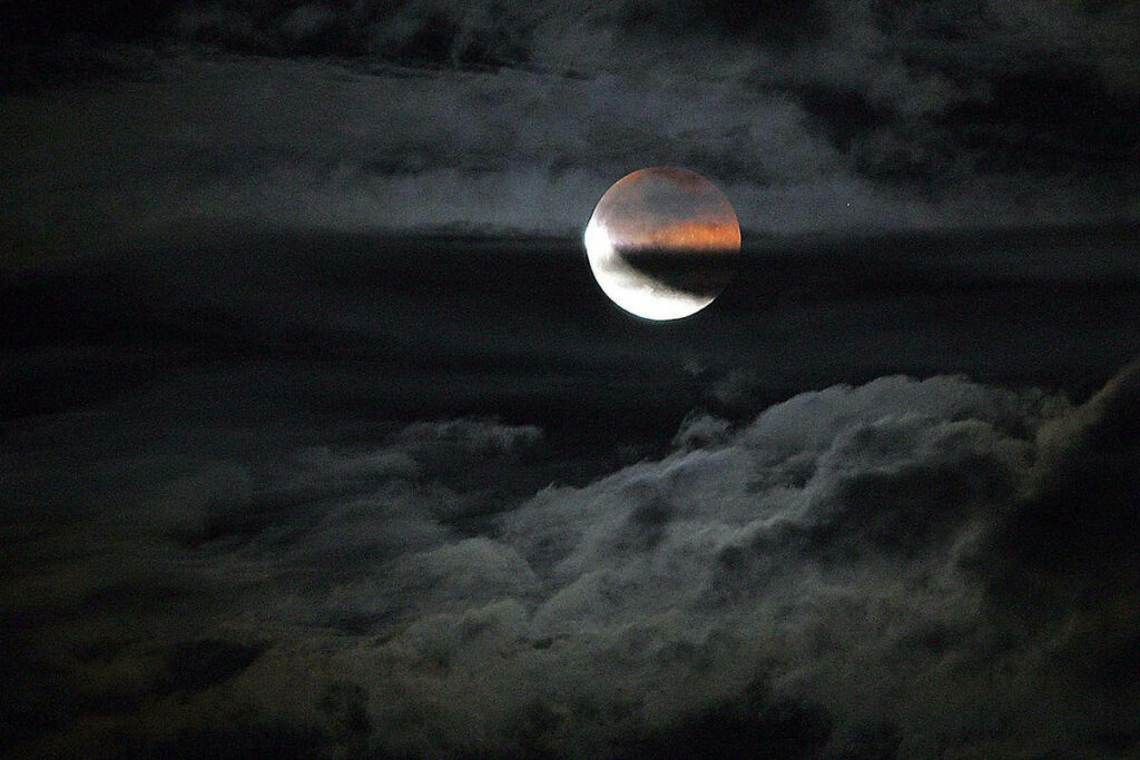 Mesmerizing Lunar Eclipse Wallpaper: Cloudy Night Scene