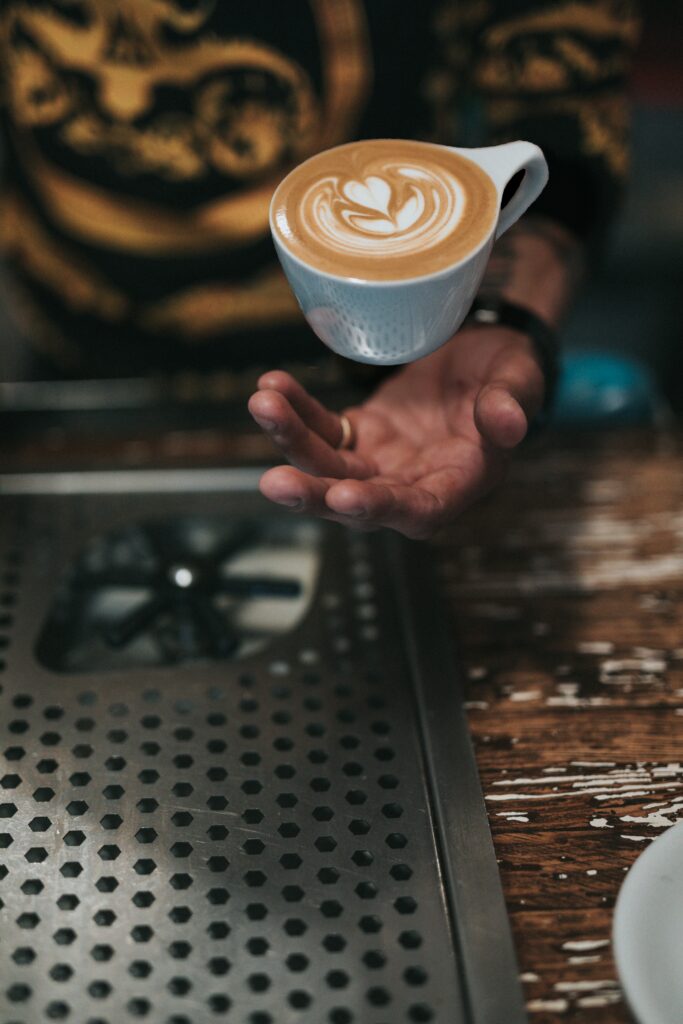 Levitation Coffee Art Wallpaper: Cup in Mid-Air Above Hand