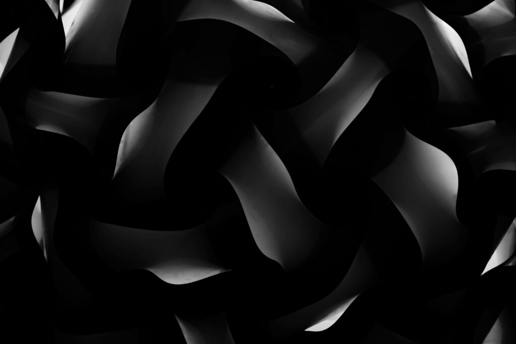 Sleek and Polished: A Stunning Black Textured Wallpaper with Subtle Grey Reflective Touches