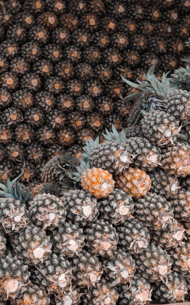 Realistic pineapple stack wallpaper showing vibrant yellow pineapples with dark green skins pattern