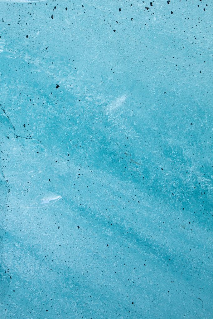 Close-up glacial ice wallpaper with cyan textures frozen bubbles and natural crystalline cracks