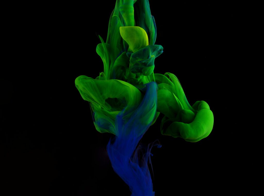 Vivid Green & Blue Liquid Ink Wallpaper Against Black Background
