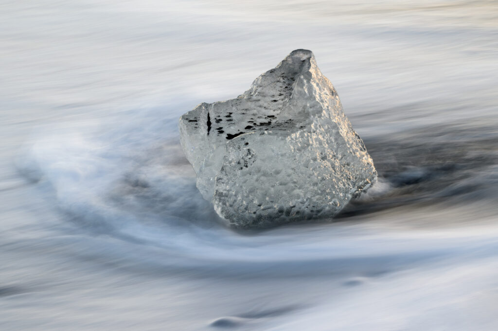 Stunning Ice Block Macro: Textured Beauty in Flowing Water Wallpaper