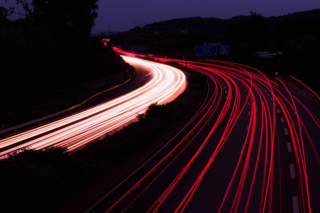 Curved Road at Night: Vibrant Long-Exposure Wallpaper Background