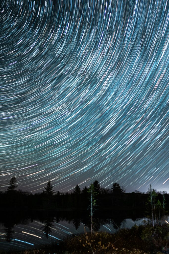 Mesmerizing Night Sky Wallpaper: Star Trails & Forest Reflection