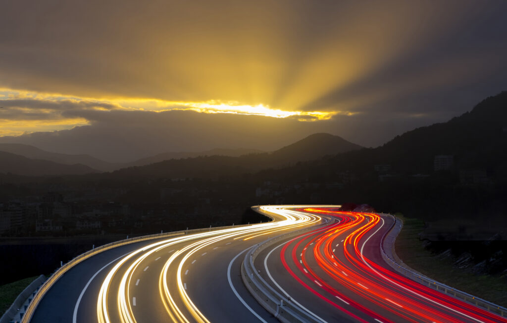Mesmerizing Nighttime Wallpaper: Curving Road with Sunset and Light Trails