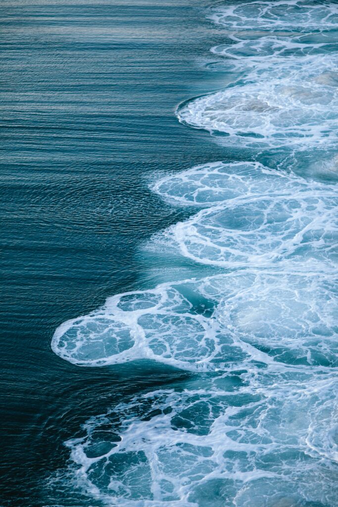 High resolution wallpaper of dynamic ocean waves with rich blue tones and detailed white foam patterns