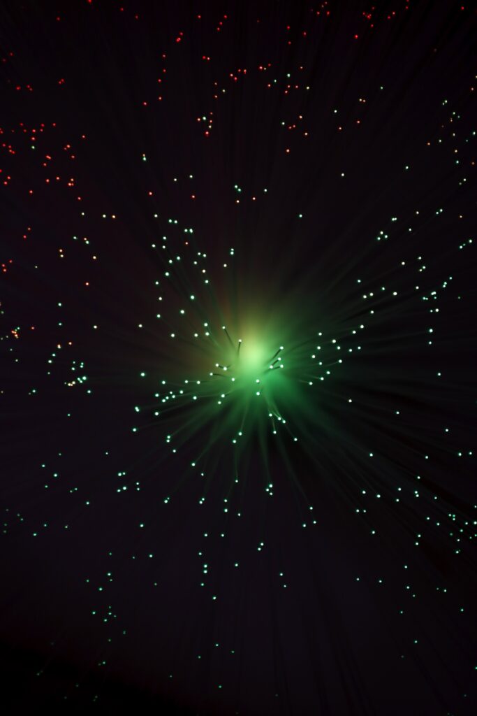Vibrant Optical Fiber Wallpaper: Glowing Green & Red in Dark Background