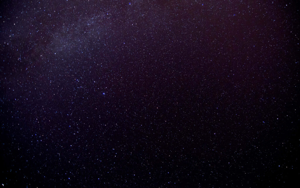 Starry outer space wallpaper with a serene dark background, evoking wonder and infinity.