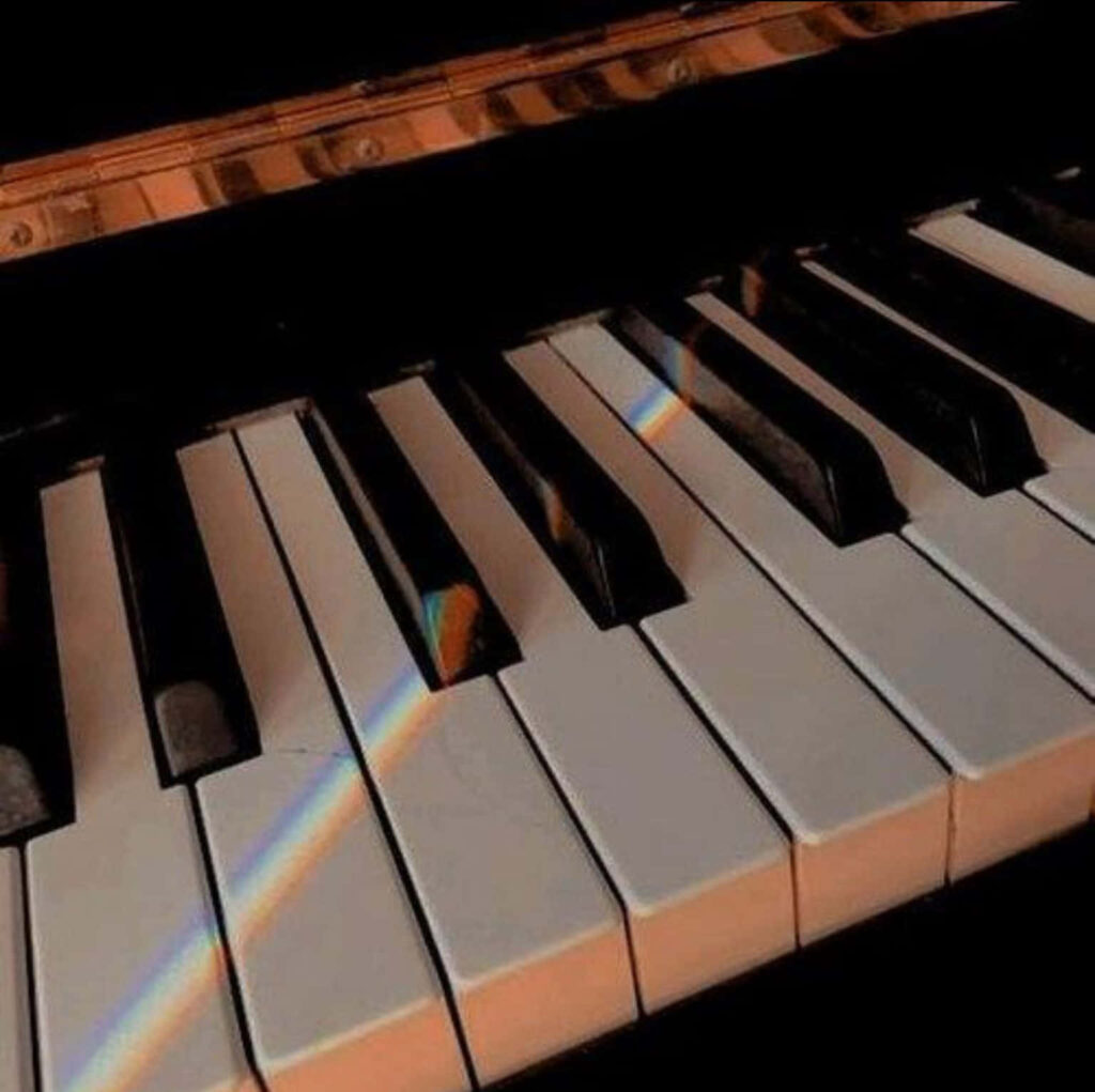 Serene Piano Keys Wallpaper with Warm Lighting & Rainbow Reflection